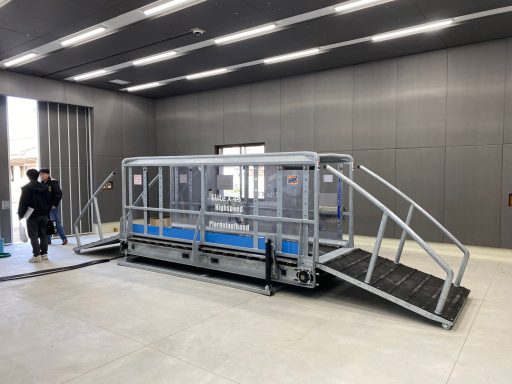 Japan - Highspeed Laufband Barrierefreier Zugang mit einer Rampe und einem Plattformlift in einem modernen Raum.
